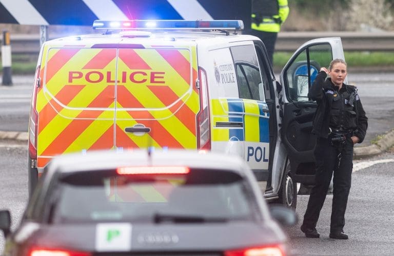 Police van with officer at scene