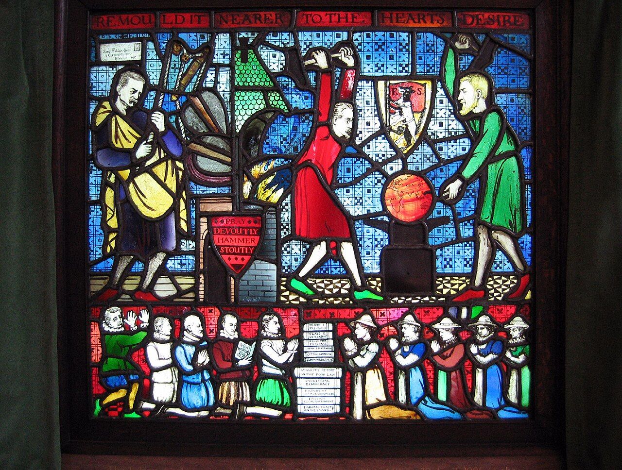 The Fabian Window at the LSE, designed by George Bernard Shaw in 1910: Shaw and Sidney Webb hammer the globe on an anvil beneath a shield bearing a wolf in sheep's clothing