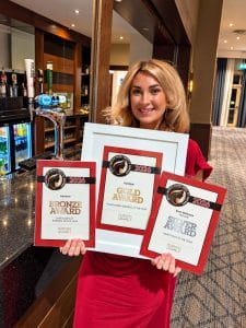 Karis Petersen holding gold, silver and bronze award certificates from the 2026 Kent Health, Hair and Beauty Awards