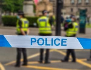 Police tape with officers behind
