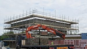Scaffolding around a partly built new block at Danecourt School in Gillingham, with a lorry unloading bricks in the foreground