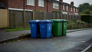 Illustrative computer-generated image of household recycling bins at the kerb of a residential street