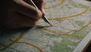 A hand drawing new boundary lines across a printed county map