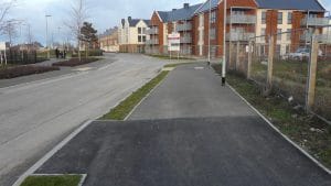 Avocet Way in the Finberry housing development at Ashford, with the carriageway on the left and a shared footway and cycleway running alongside apartment blocks