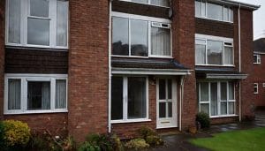 Modern brick residential flats under an overcast autumn sky, illustrative image