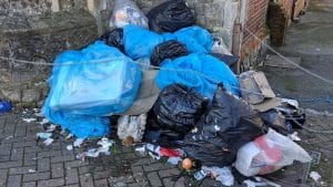 Bags of fly-tipped rubbish dumped against a wall