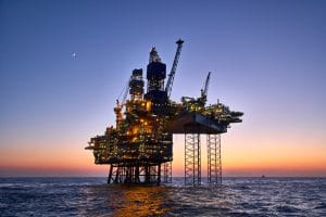 An offshore oil and gas production platform with a jack-up rig at sea