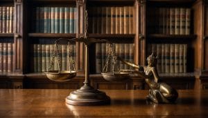 Illustration of brass scales of justice in front of shelves of law books