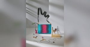 The Sophia 21 handbag in turquoise and pink leather, with leatherworking tools